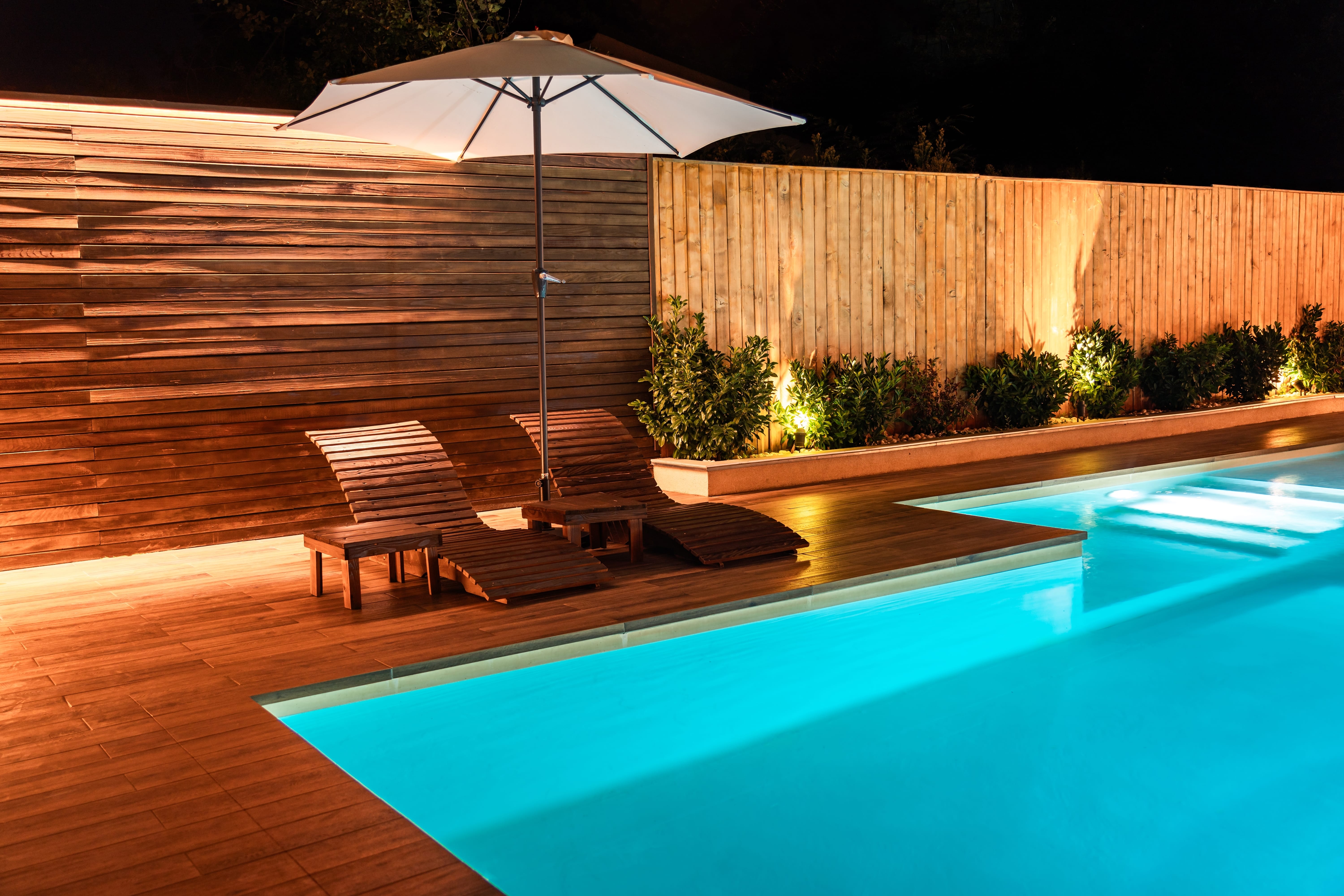 luxe,piscine,avec,terrasse,en,bois,et,transats,stylés,au,soleil